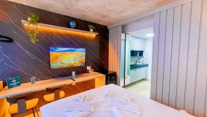 a room with a bed and a tv on a wall at Setai Yacht Premium - By Almare Flats in João Pessoa