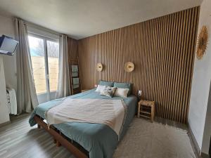 une chambre avec un lit et une grande fenêtre dans l'établissement Maison de location hypercentre, à La Tranche-sur-Mer