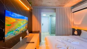 a bedroom with a bed and a flat screen tv at Setai Yacht Premium - By Almare Flats in João Pessoa