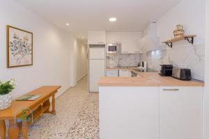 eine Küche mit weißen Schränken und einem Holztisch in der Unterkunft 2 bed 2 bath Magnus Apartment in El Campello + 14 Fotos