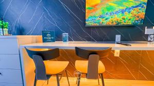 a counter with two chairs and a painting on the wall at Setai Yacht Premium - By Almare Flats in João Pessoa