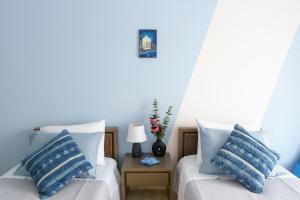 two beds in a room with blue walls at S K apartments K in Argostoli