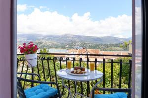 a table on a balcony with a view of the mountains at S K apartments K in Argostoli