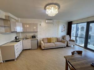 a kitchen and living room with a couch and a table at Orbi Eva Aparatments in Batumi