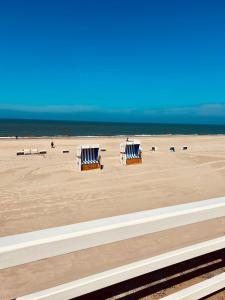 two blue and white chairs sitting on the beach at Haus Westerhörn in Westerland