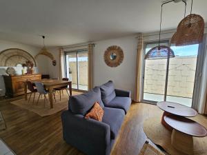 un salon avec un canapé bleu et une table dans l'établissement Maison de location hypercentre, à La Tranche-sur-Mer