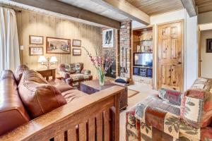 ein Wohnzimmer mit einem Ledersofa und einem TV in der Unterkunft Top-Floor Condo Downtown with Stunning Views in Aspen