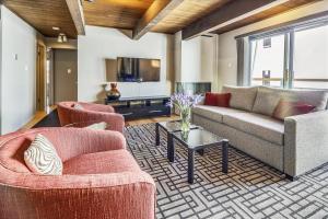 a living room with two couches and a tv at Modern Condo, 1 Block to Gondola - Ideal Vacation Location in Aspen