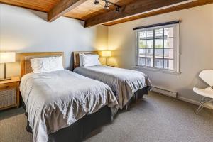 two beds in a room with a window at Modern Condo, 1 Block to Gondola - Ideal Vacation Location in Aspen