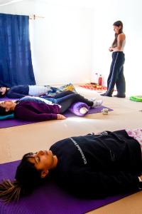 three girls laying on the floor in a yoga class at Re-Crearte Centro Holístico in San Carlos de Bariloche