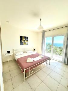 a bedroom with a large bed and a large window at Villa Georgia in Lourdhata +13 photos