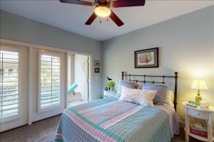 a bedroom with a bed and a ceiling fan at Garden Cottage 23 in Jekyll Island +40 photos