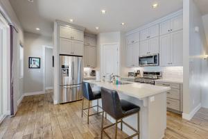 a kitchen with white cabinets and a kitchen island with bar stools at Pinnacle Pines in Flagstaff