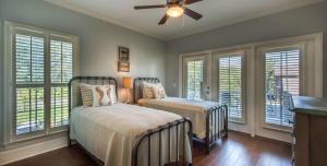 a bedroom with two beds and a ceiling fan at Poolside Cottage 32 in Jekyll Island +28 photos