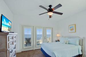 a bedroom with a bed and a ceiling fan at Ocean Cottage 44 in Jekyll Island +47 photos