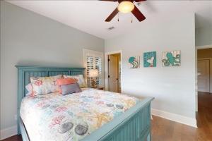 a bedroom with a bed and a ceiling fan at Poolside Cottage 57 in Jekyll Island +46 photos