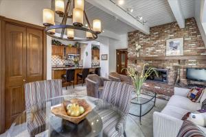 a living room with a table with a bowl of fruit on it at Lovely Aspen Condo with Mountain Views & Hot Tub in Aspen