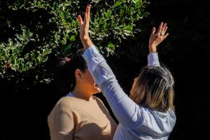 two women with their hands up in the air at Re-Crearte Centro Holístico in San Carlos de Bariloche +6 photos