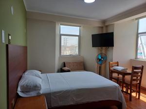 ein Schlafzimmer mit Bett, Stuhl und Fernseher in der Unterkunft HsDverdi in Santa María