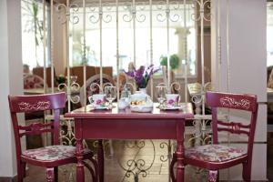 a table with two chairs and a vase with flowers on it at Parthenon Art Hotel-Seaside Collection in Olympic Beach