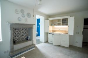 Le Cornici Home Suites - Apartments - Lake Idro في Ponte Caffaro: مطبخ مع موقد و دواليب بيضاء