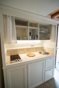 Le Cornici Home Suites - Apartments - Lake Idro في Ponte Caffaro: مطبخ بخزائن بيضاء ومغسلة +23 صورة