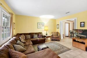 uma sala de estar com um sofá e uma TV em Carole Cottage em Jekyll Island