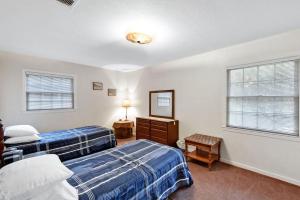 um quarto com 2 camas, uma cómoda e 2 janelas em Carole Cottage em Jekyll Island mais 17 fotografias