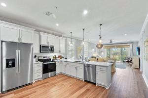 a kitchen with white cabinets and stainless steel appliances at Moorings 104 in Jekyll Island