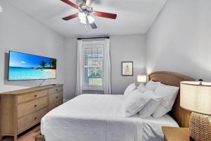 a bedroom with a bed and a ceiling fan at Moorings 104 in Jekyll Island +21 photos