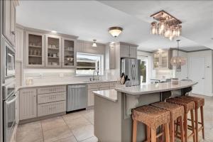 eine Küche mit weißen Schränken und eine Insel mit Barhockern in der Unterkunft Casa Blanca Cottage in Jekyll Island