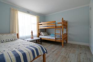 a bedroom with a bed and bunk beds in it at Tassies in Gansbaai