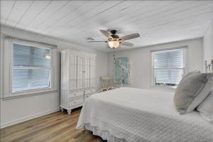 ein weißes Schlafzimmer mit einem Bett und einem Deckenventilator in der Unterkunft Casa Blanca Cottage in Jekyll Island + 22 Fotos