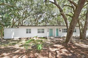 a white house with a tree in front of it at Brice Sea Shell Stay in Jekyll Island