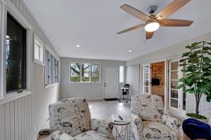 ein Wohnzimmer mit 2 Stühlen und einem Deckenventilator in der Unterkunft A Wave From It All in Jekyll Island