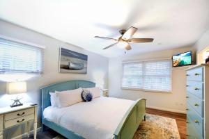 Schlafzimmer mit einem blauen Bett und einem Deckenventilator in der Unterkunft A Wave From It All in Jekyll Island + 23 Fotos