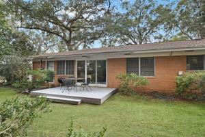 uma casa com um pátio com mesa e cadeiras em Lanier Cottage em Jekyll Island