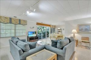 uma sala de estar com dois sofás e uma televisão em Lanier Cottage em Jekyll Island