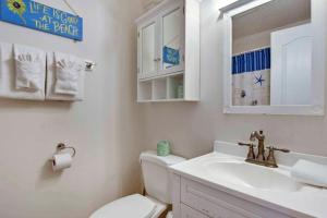a white bathroom with a toilet and a sink at Gritz Carlton B in Jekyll Island +12 photos