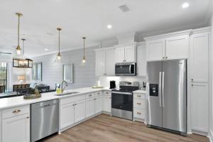 a kitchen with white cabinets and a stainless steel refrigerator at Moorings 206 in Jekyll Island