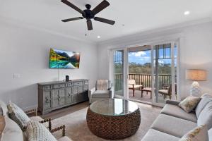 a living room with a couch and a ceiling fan at Moorings 206 in Jekyll Island