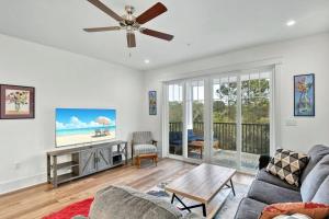 a living room with a couch and a ceiling fan at Moorings 107 in Jekyll Island