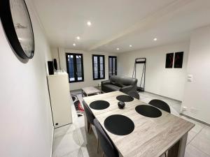 a living room with a wooden table and chairs at L'Évasion en Bord de Seine in Bray-sur-Seine