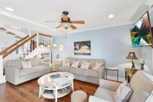 ein Wohnzimmer mit 2 Sofas und einem Deckenventilator in der Unterkunft Villa 103 Drift on Inn in Jekyll Island