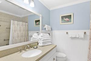 ein Badezimmer mit Waschbecken, Spiegel und Toilette in der Unterkunft Villa 103 Drift on Inn in Jekyll Island + 23 Fotos