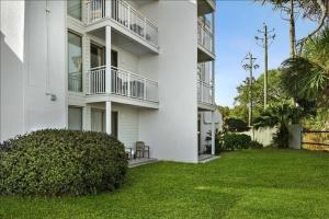 ein weißes Gebäude mit einem grünen Hof davor in der Unterkunft Villa 103 Drift on Inn in Jekyll Island