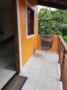 a porch with a hammock hanging from a house at Chalé aconchego do Áureo 2 in Pacoti