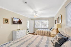 a bedroom with a bed and a ceiling fan at Newbern Cottage in Jekyll Island +21 photos