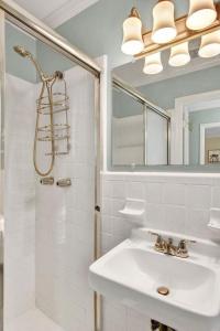 a white bathroom with a sink and a shower at Newbern Cottage in Jekyll Island +22 photos
