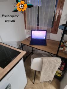 a laptop computer sitting on a desk with a chair at Golden Cottage Stade P Mauroy Lille in Villeneuve d'Ascq